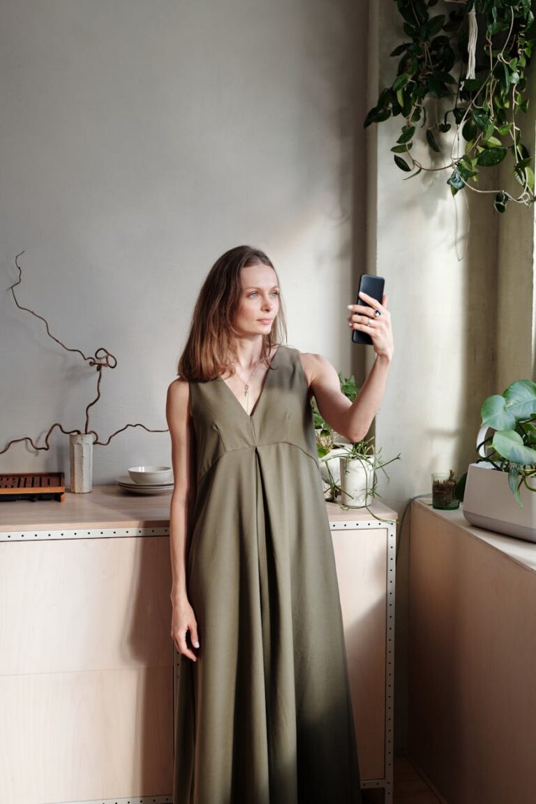 woman in a green long dress holding a smartphone